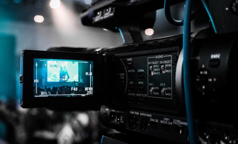 A stock photo from Pexels of a video camera at a conference
