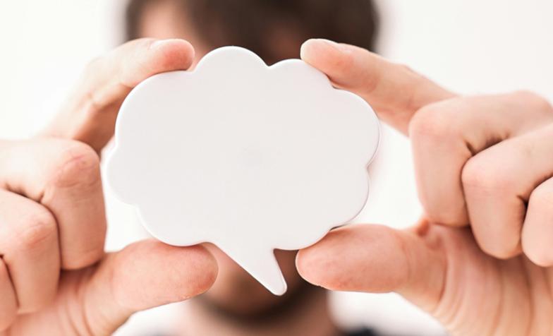 A stock photo from Pexels depicting a man holding up a speech bubble