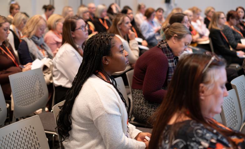 An audience of people seated at a conference session.