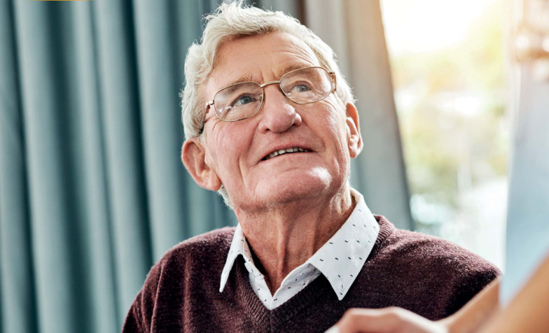 An elderly man looks up at someone out of frame.