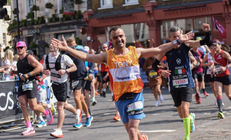 Someone running with their arms wide, smiling