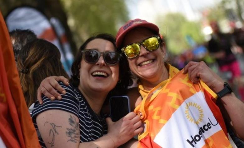 Two people hugging, with one holding up a Hospice UK running vest 