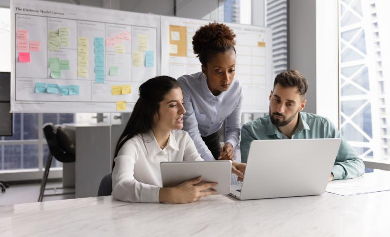 3 people looking at a laptop