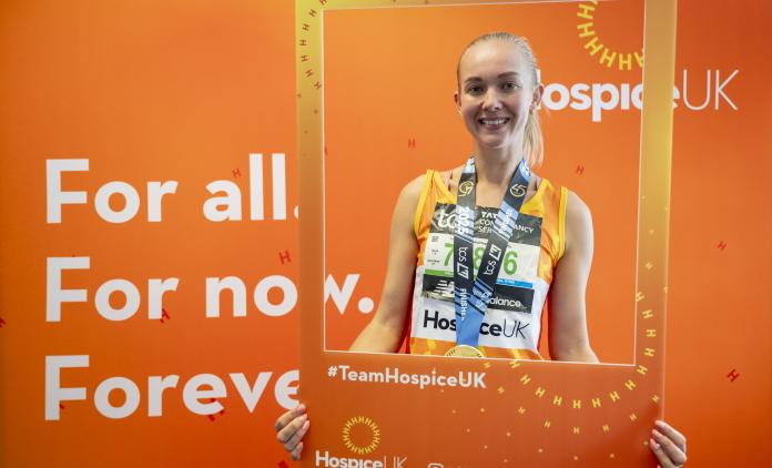 Hospice UK runner holding up an orange picture frame