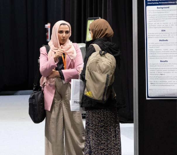 Two women having a conversation next to the poster exhibition at National Conference
