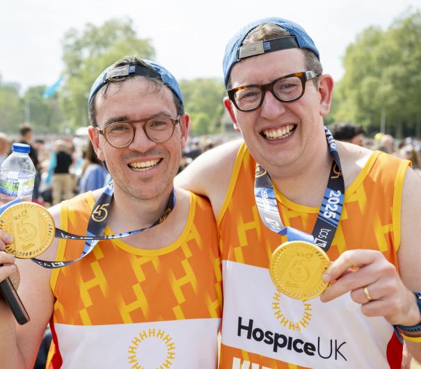 Two Hospice UK runners celebrate completing the London Marathon
