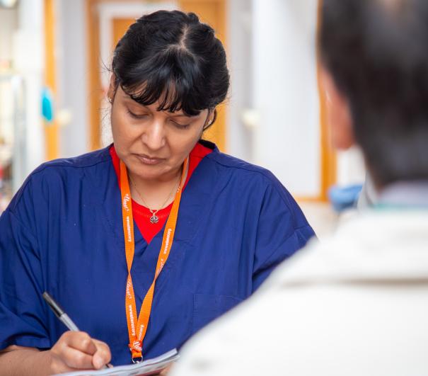 A nurse recording clinical outcomes