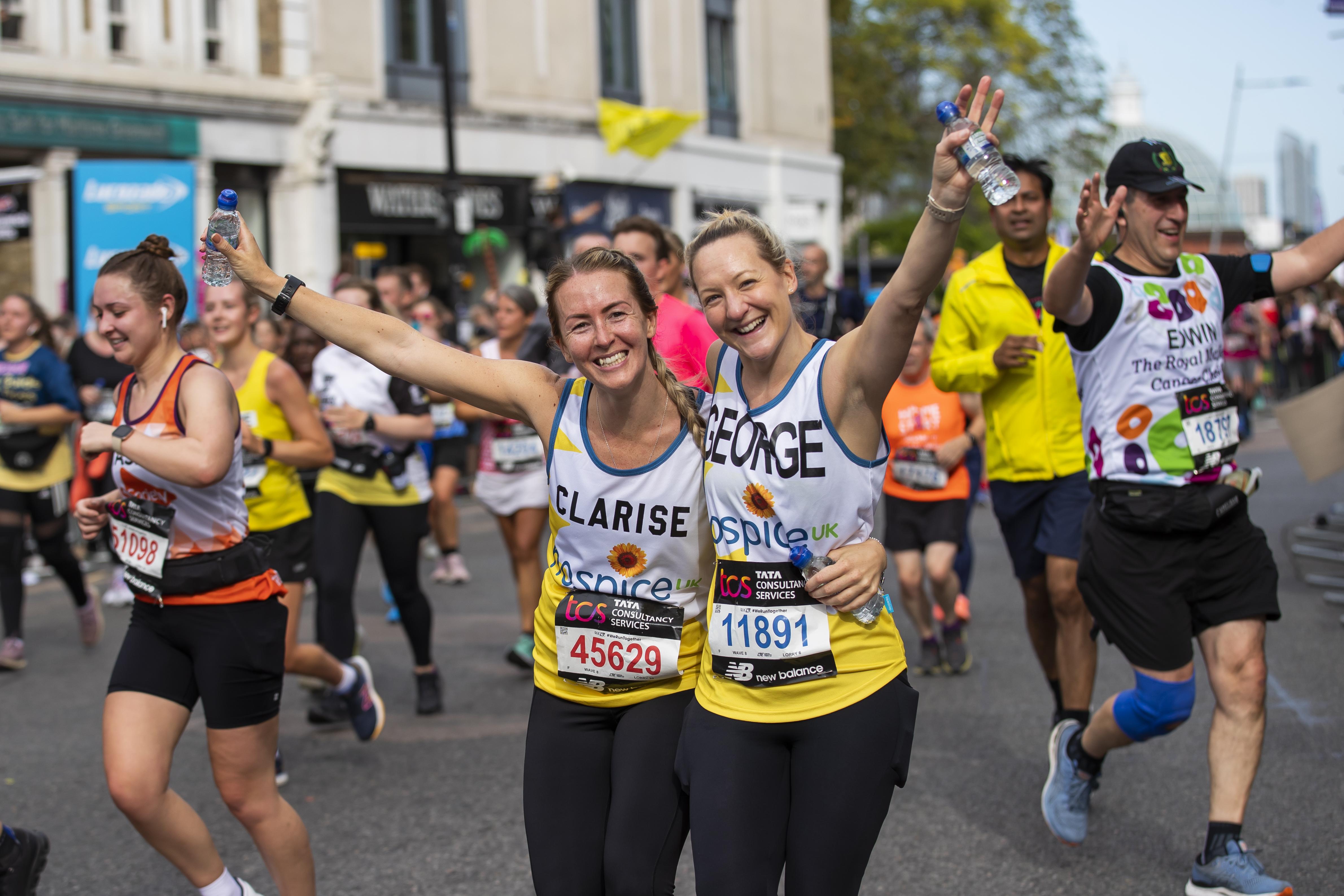 Two women in Hospice UK vests celebrating at Greenwich cheer point