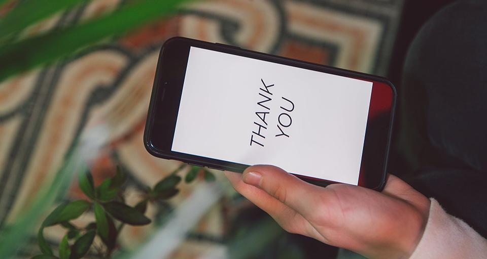 A stock photo of an iPhone displaying a thank you message