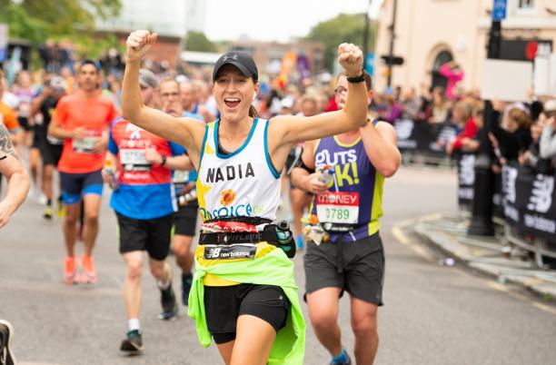Female runner cheering in Hospice UK vest