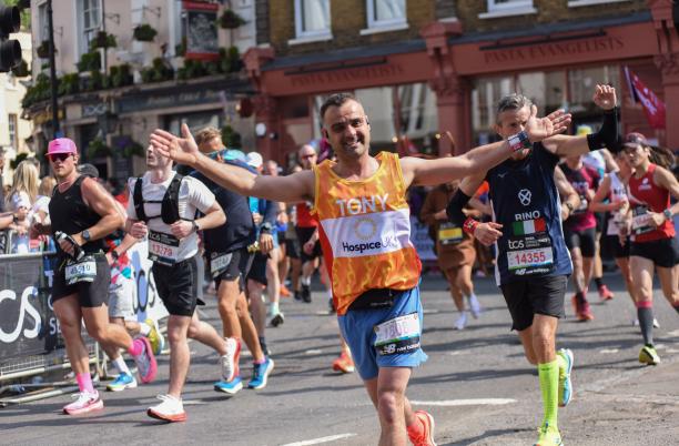 Someone running with their arms wide, smiling