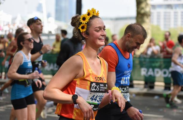 Person running in a Hospice UK Vest with a sunflower headband