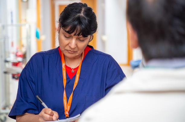A nurse recording clinical outcomes