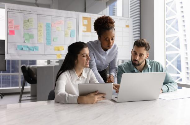3 people looking at a laptop