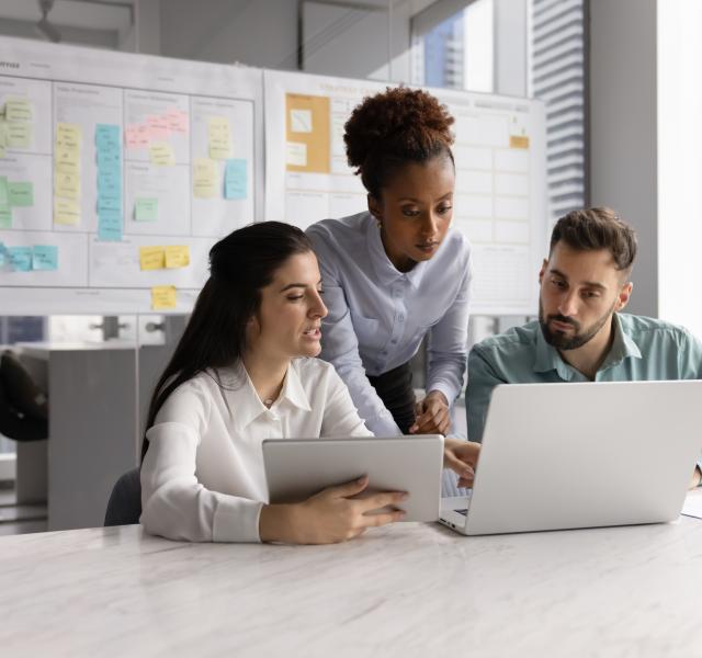 3 people looking at a laptop