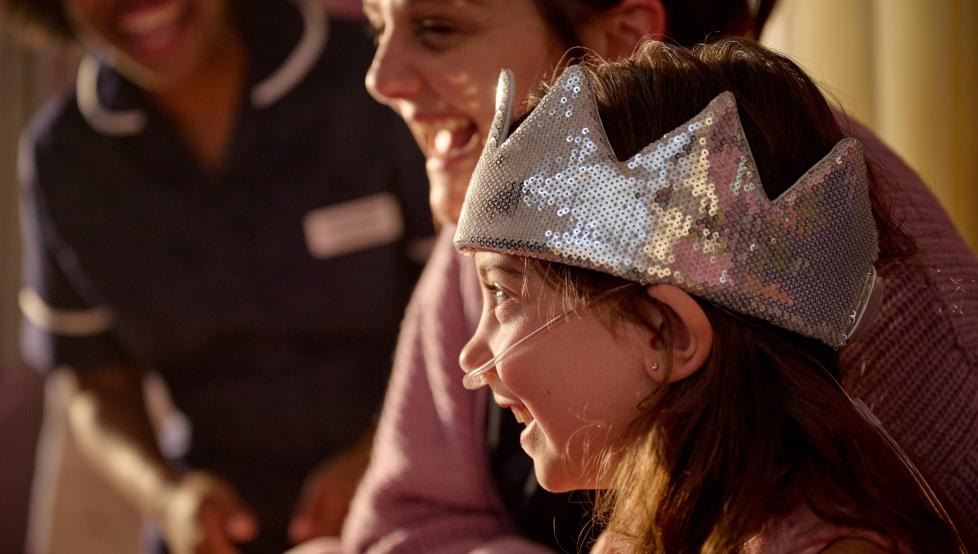 From This is Hospice Care legacy campaign - child wearing a party crown and a feeding tube