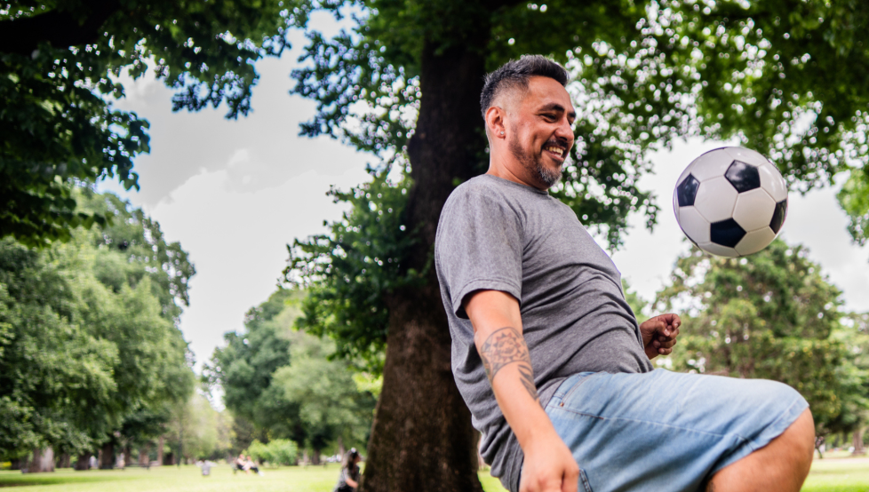 A stock photo of someone bouncing a football on their knee