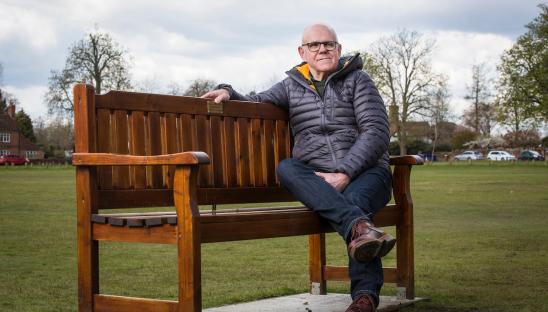 David sitting on a bench dedicated to his father