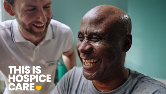 A man in a grey t shirt is laughing with a man in a white t shirt. The text in the corner reads 'This is hospice care'.