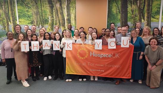 Hospice UK banner with lots of people stood behind holiding 'THANK YOU' signs