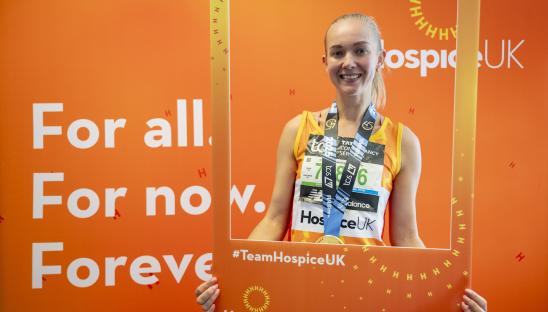 Hospice UK runner holding up an orange picture frame